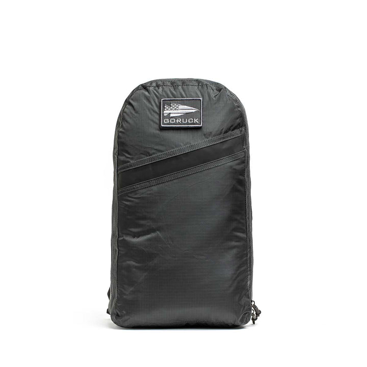 The Packable Bullet Ruck - Ripstop ROBIC® is a black GORUCK backpack made from robust ripstop nylon, featuring a front zip pocket and logo patch—ideal as a lightweight day bag.