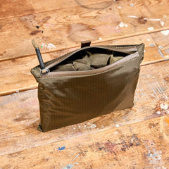 GORUCK packable ranger green zippered pouch on distressed wooden surface