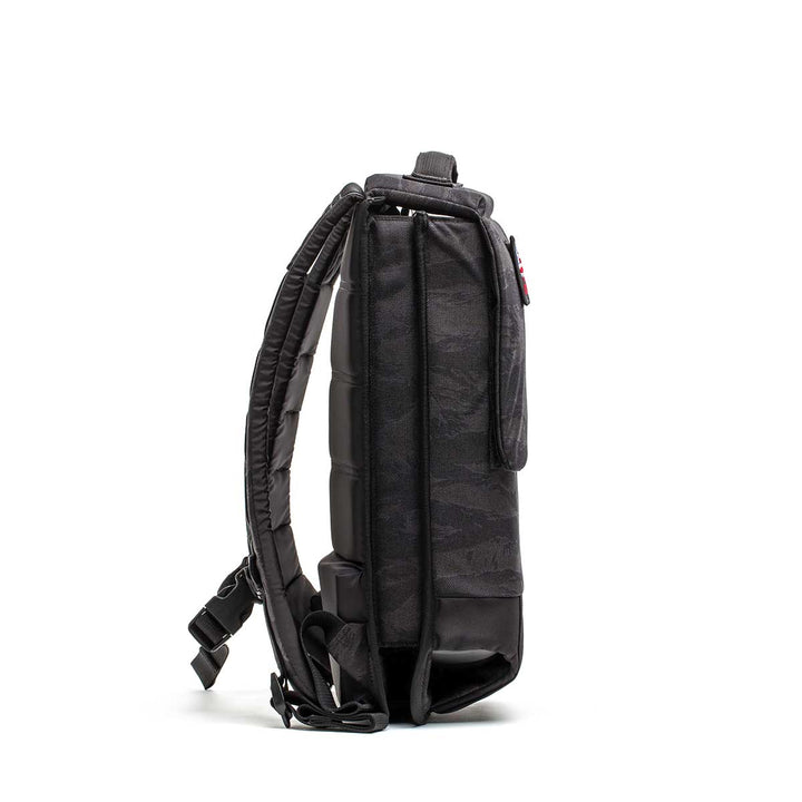 Side view of the GORUCK Ruck Plate Carrier 3.0 in black, featuring padded design and adjustable straps for carrying workout equipment, shown against a white background.