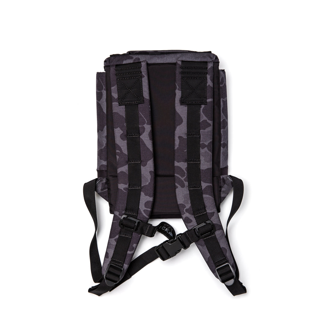 The GORUCK Ruck Plate Carrier 3.0, shown from the back in black and gray camo, features padded shoulder straps, ergonomic lumbar support, and a chest buckle.