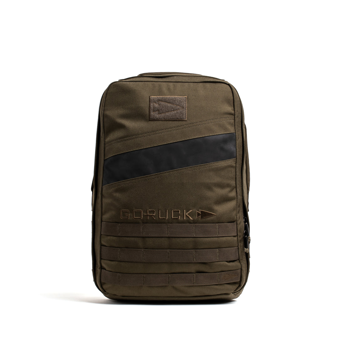 The GORUCK Rucker 4.0 is an olive green backpack with a black diagonal stripe, front "GORUCK" logo, and MOLLE webbing—ruggedly built for fitness training and ideal as a weighted rucksack.
