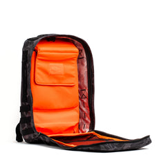 The GORUCK Rucker 4.0 is an open black rucksack with a bright orange interior and multiple compartments, ideal for rucking, displayed against a white background.