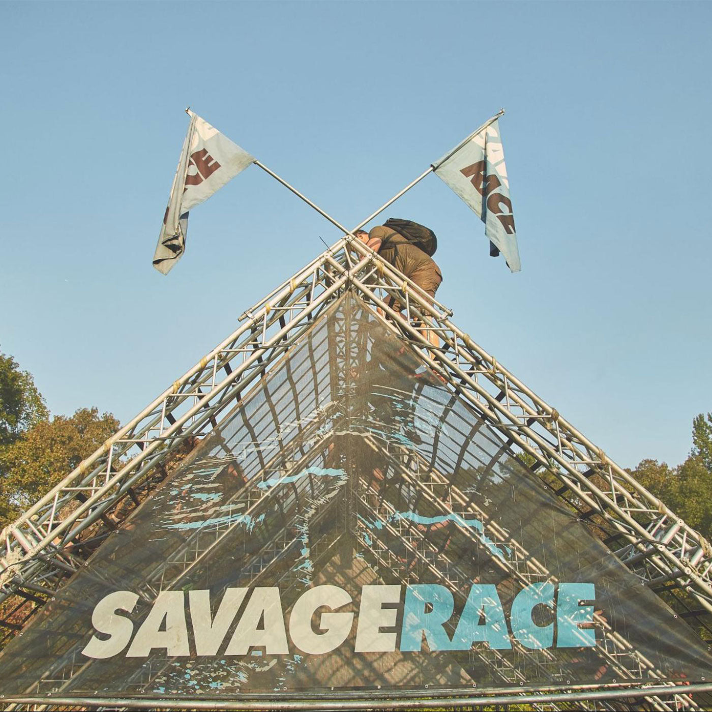 Person climbs a metal obstacle with 