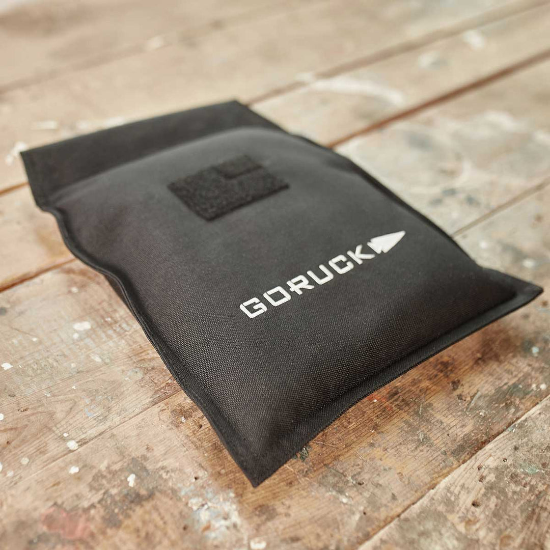 A GORUCK Ruck Sandbag - 10LB (4.5KG) sits on a weathered wooden surface, ready to elevate your next workout.