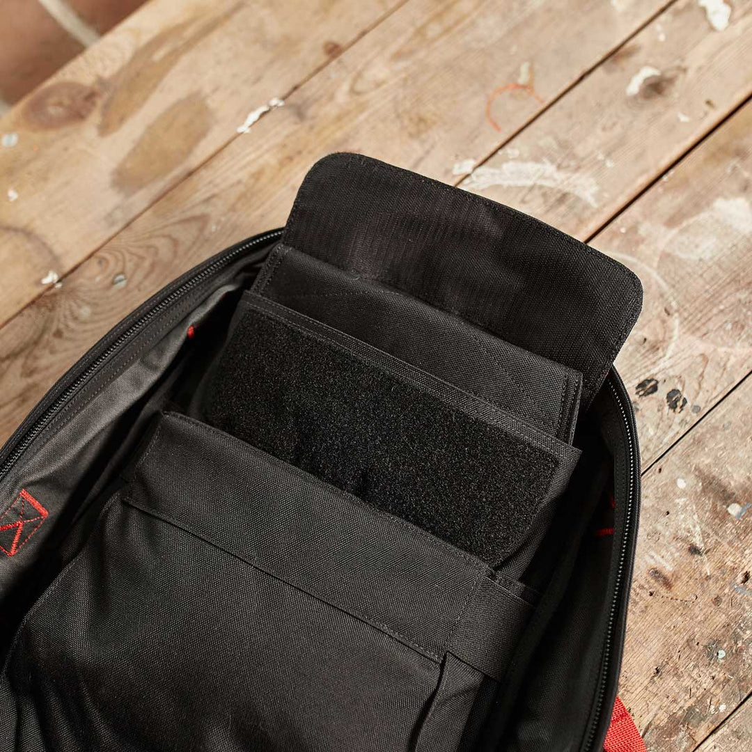 Open black GORUCK Ruck Sandbag - 10LB (4.5KG) with multiple compartments on a worn wooden surface, viewed from above—ideal for organizing workout gear or adding a ruck plate to boost your training intensity.