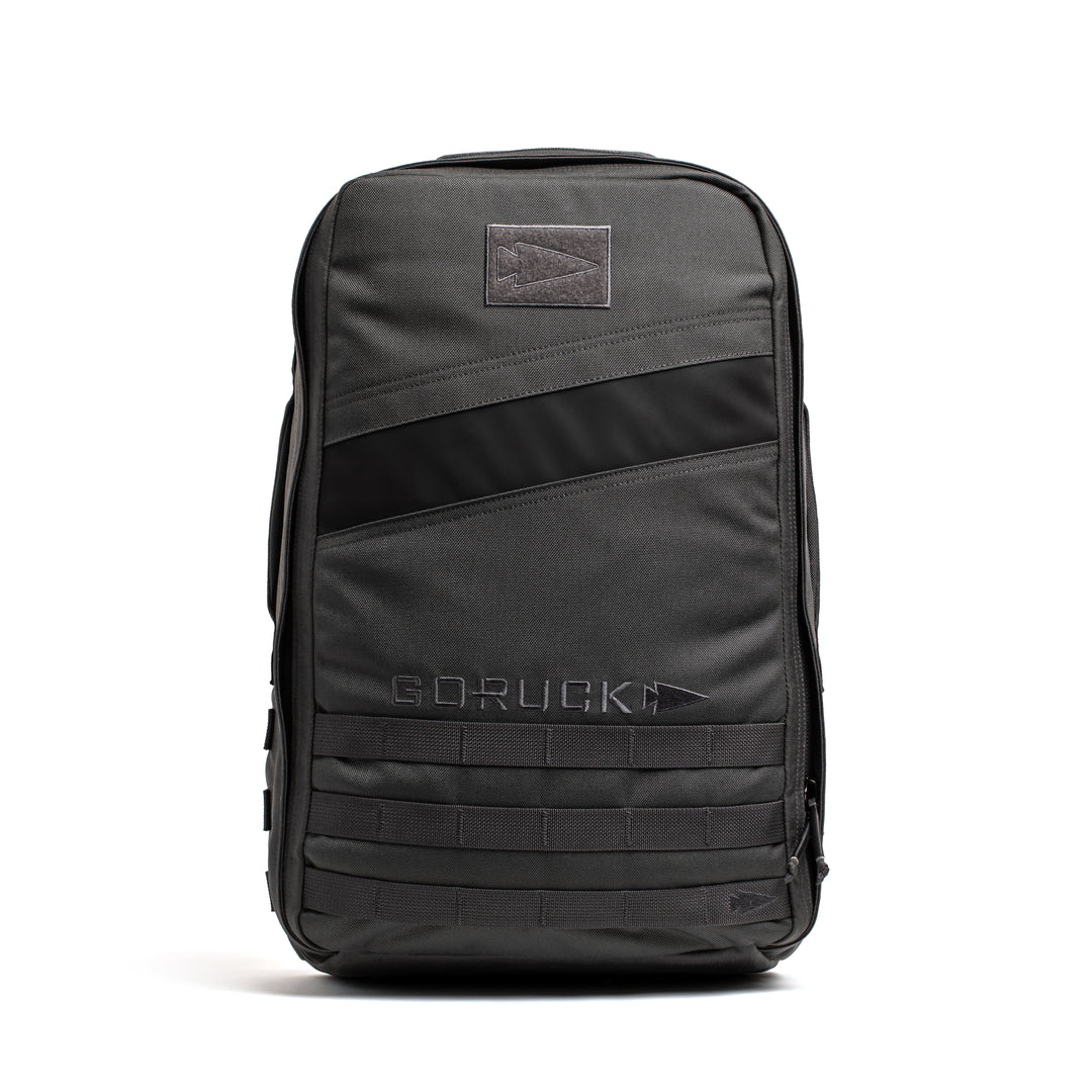 The GORUCK Rucker 4.0 is a black tactical rucking backpack with MOLLE webbing and a front diagonal zipper pocket, ideal for carrying your rucking gear, displayed against a white background.