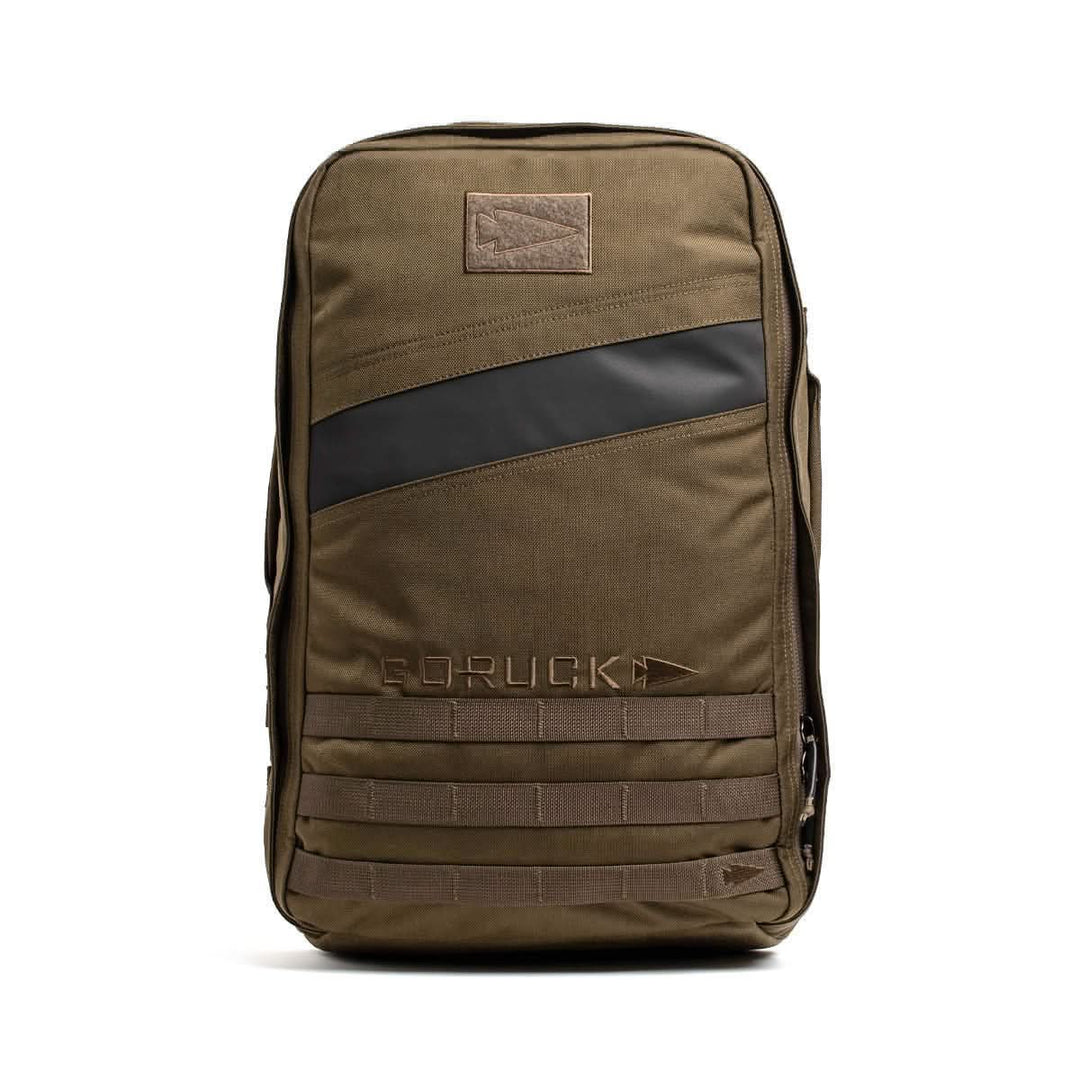The GORUCK Rucker 4.0 backpack in brown features a black diagonal stripe and front MOLLE webbing, ideal for rucking with Ruck Plates; displayed on a white background.