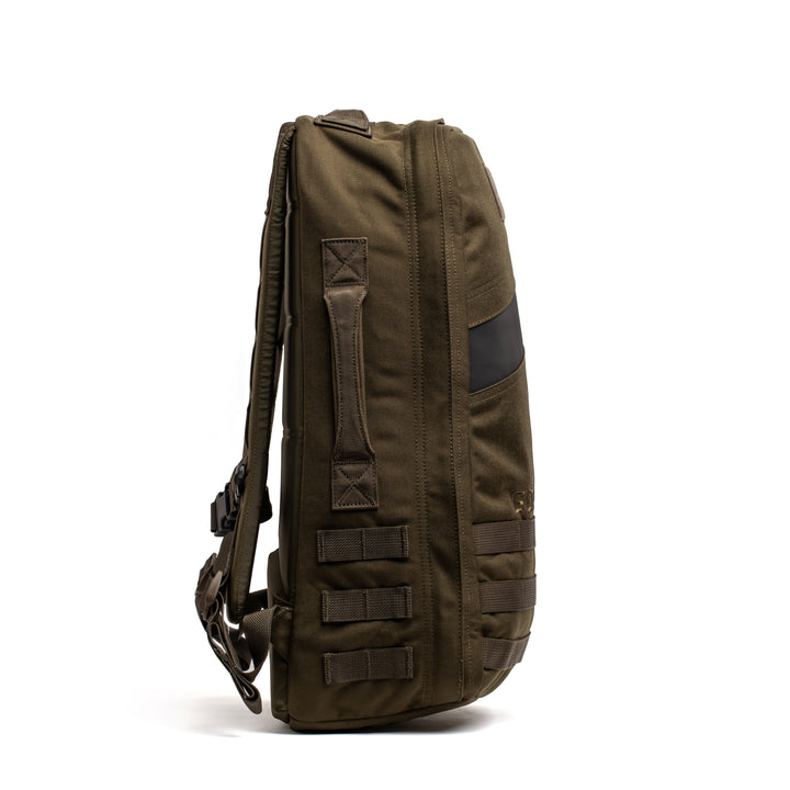 Side view of the GORUCK Rucker 4.0 backpack in olive green, featuring multiple straps and a rugged design, displayed against a white background.