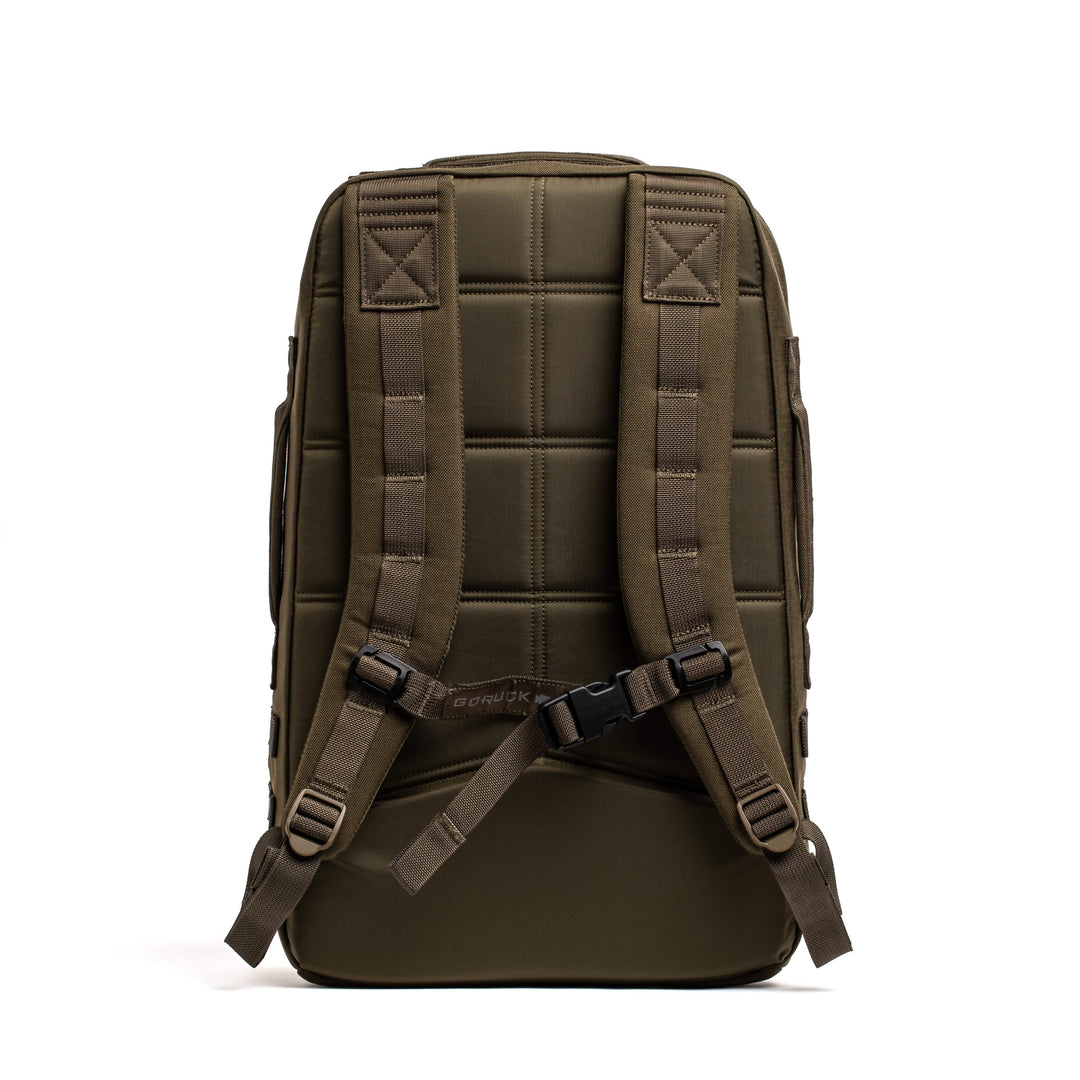The GORUCK Rucker 4.0 in olive green is shown from the back on a white background, displaying padded straps and a chest buckle.