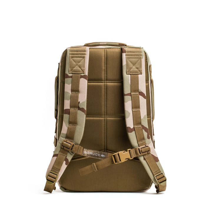 The GORUCK Rucker 4.0 camouflage rucking backpack is shown from the back, highlighting its padded shoulder straps and supportive back panel.