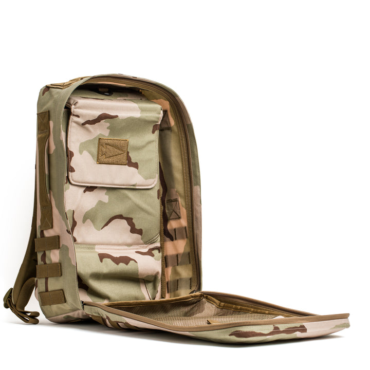 The GORUCK Rucker 4.0, a tan and green camouflage rucking backpack with front pockets, is shown open on a white background.