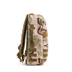 The GORUCK Rucker 4.0, a tan and brown camouflage rucking backpack, stands upright in a side view against a white background.