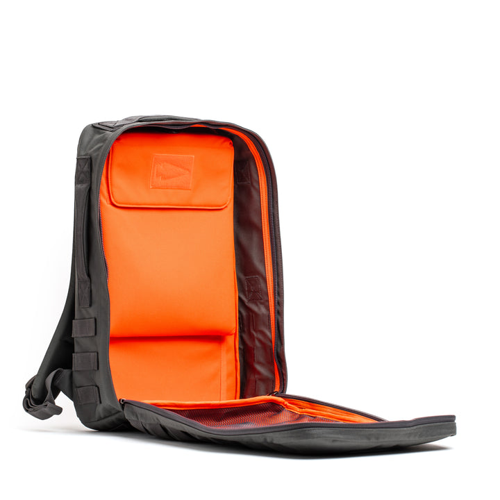 The GORUCK Rucker 4.0 is a black rucking backpack featuring a fully open front, bright orange interior, and mesh pocket.