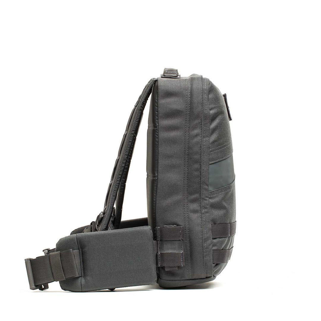 Side view of the GORUCK Rucker 4.0, a black compact rucking backpack with padded strap and multiple compartments, shown as a crossbody sling bag against a white background.