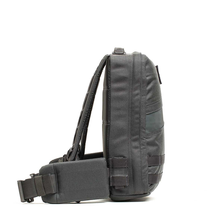 Side view of the GORUCK Rucker 4.0, a black compact rucking backpack with padded strap and multiple compartments, shown as a crossbody sling bag against a white background.