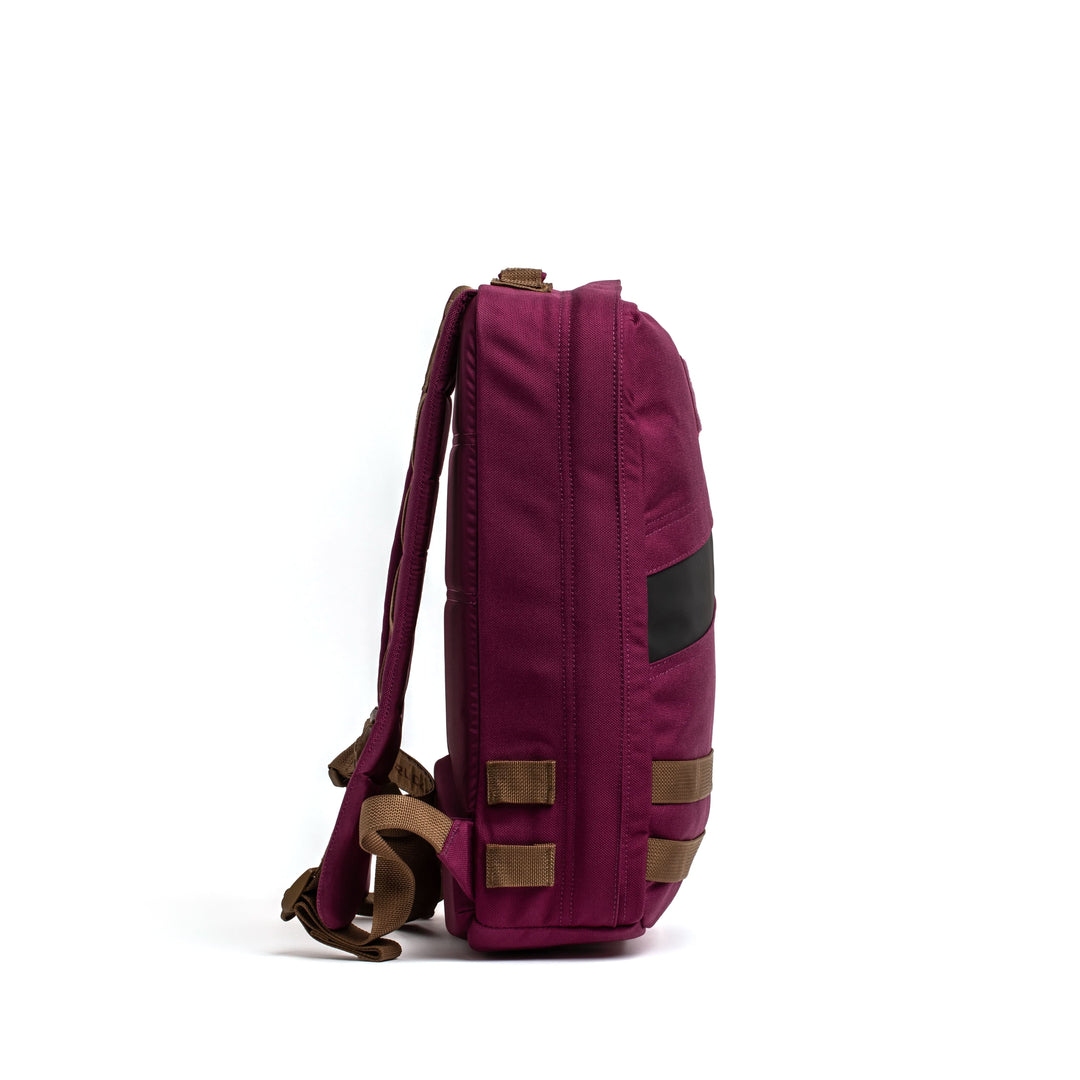 A magenta GORUCK Rucker 4.0 rucksack with brown straps, shown from the side against a white background.