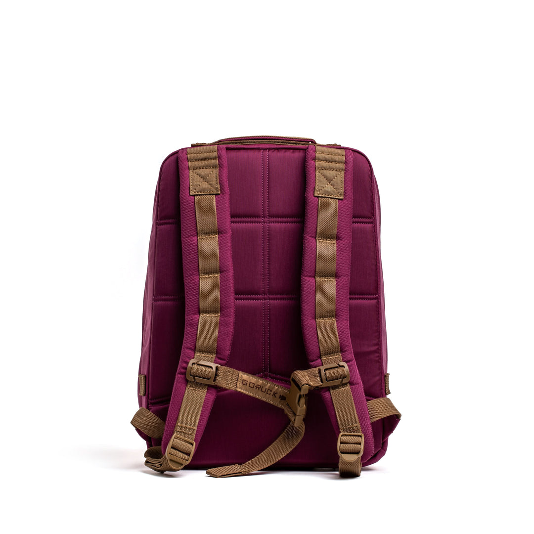 A maroon GORUCK Rucker 4.0 rucksack with brown padded shoulder straps, shown from the back on a white background. Ideal for rucking and daily adventures.