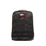 The Rucker 4.0 is a black camo rucksack featuring a handle and front patch with the American flag and "GORUCK" text—ideal for rucking or carrying Ruck Plates.