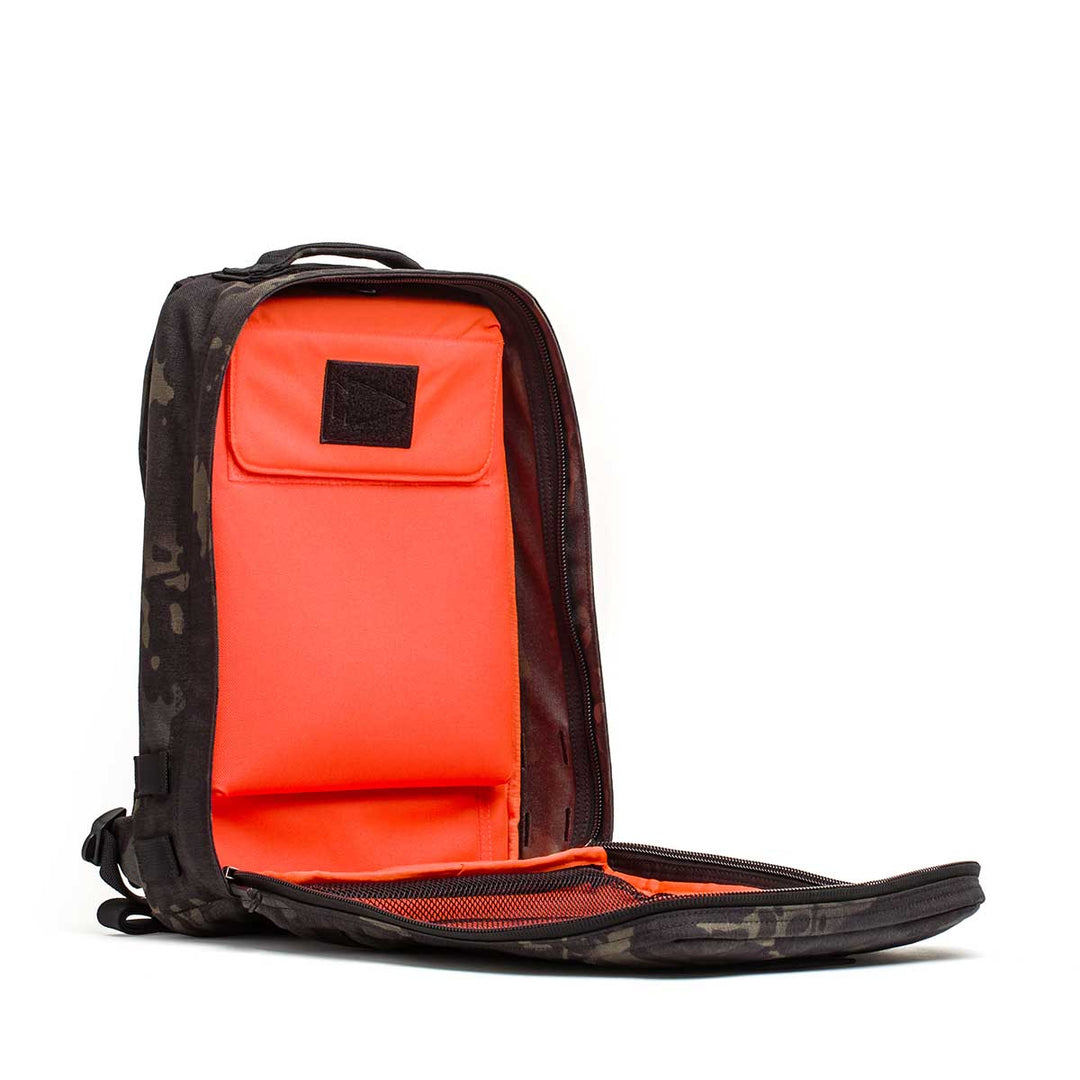 The GORUCK Rucker 4.0 backpack in black features a bright orange interior with compartments and a mesh pocket—ideal for organizing gear or carrying Ruck Plates on your next adventure.