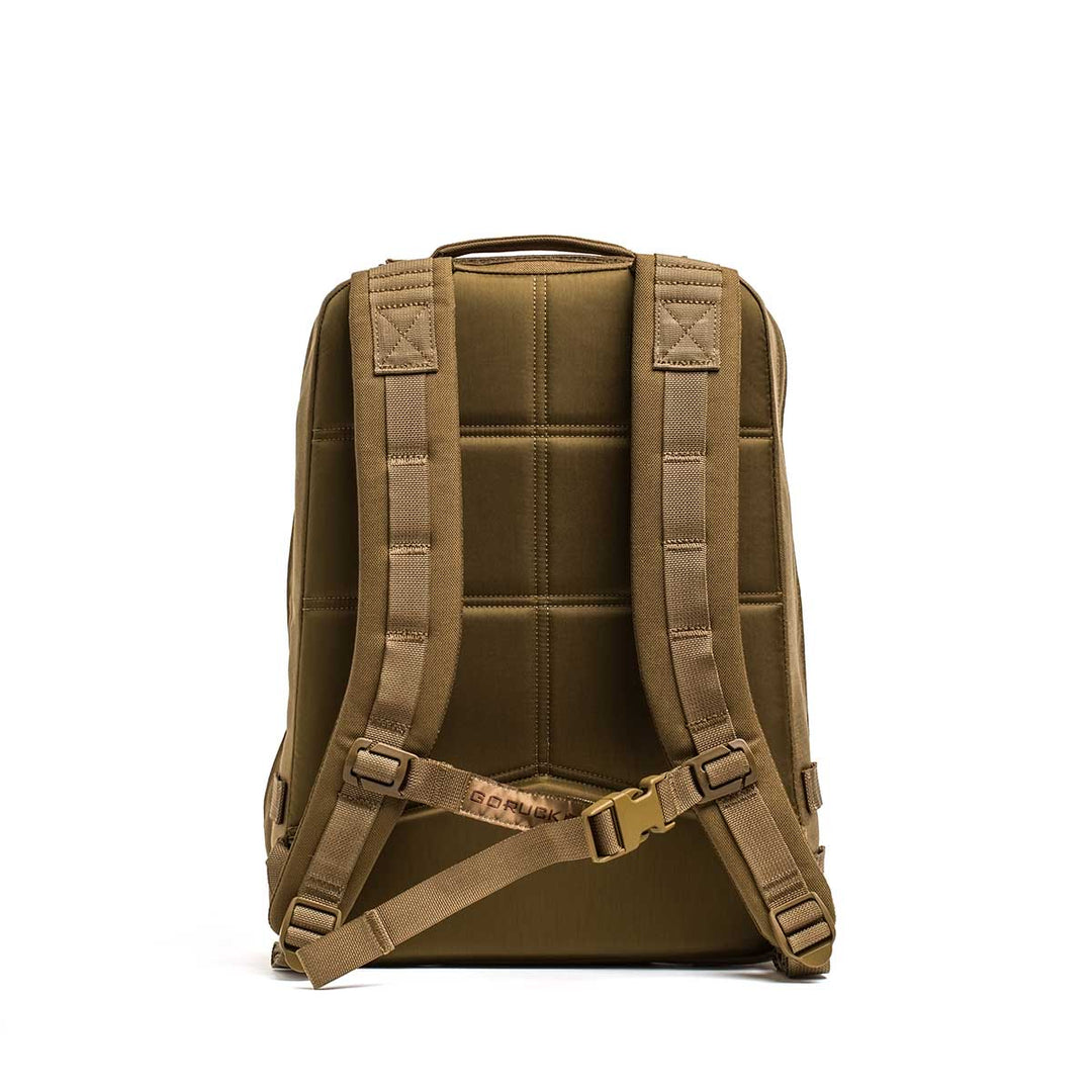 A tan GORUCK Rucker 4.0 backpack is shown from the back on a white background, featuring padded straps for rucking and a top handle.