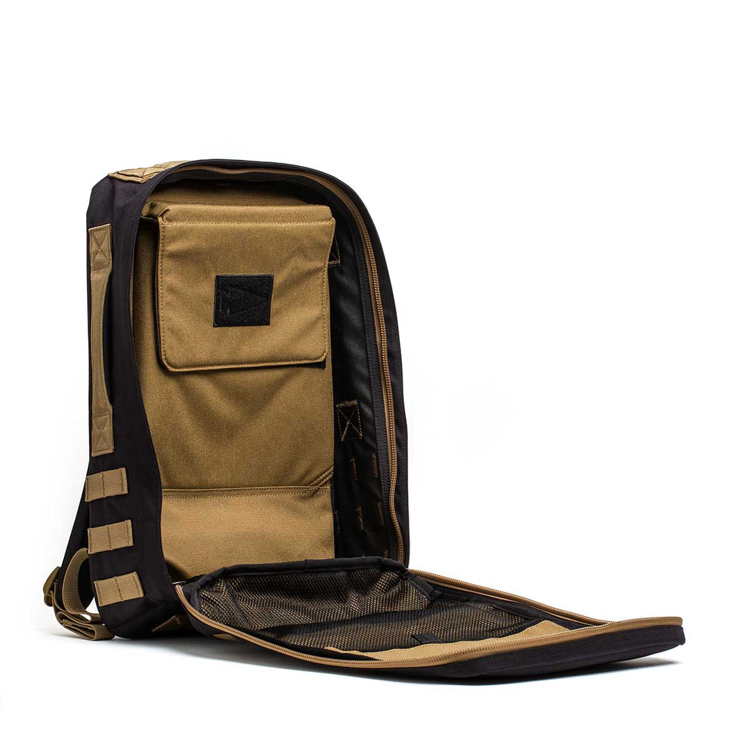 The GORUCK Rucker 4.0 in tan and black is open, revealing an interior pocket and mesh compartment ideal for carrying ruck plates.