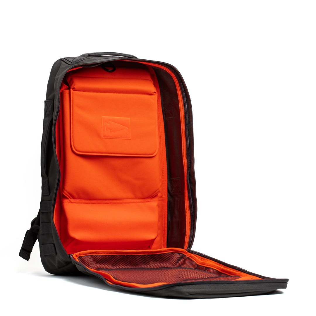 The GORUCK Rucker 4.0 backpack in black features an open front flap that reveals a vivid orange interior with multiple pockets, making it ideal for rucking or daily use.