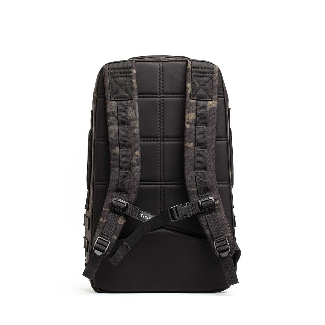 The GORUCK Rucker 4.0 backpack, shown from the back, features a padded back panel, camouflage straps, and a chest buckle. Designed for rucking, it's compatible with Ruck Plates.