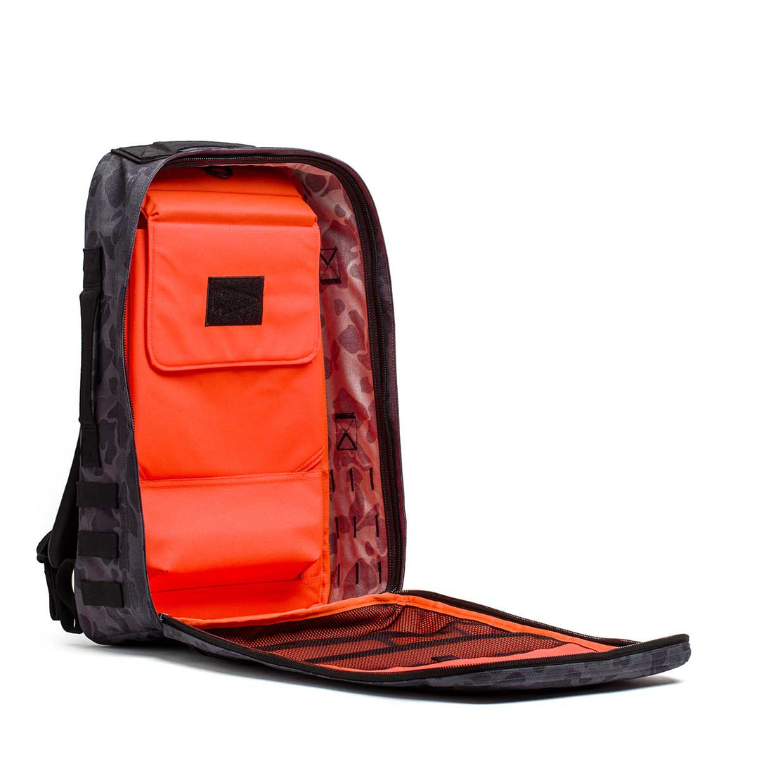 The GORUCK Rucker 4.0 is a black camouflage rucksack with a bright orange interior and multiple compartments—ideal for keeping your rucking essentials organized.
