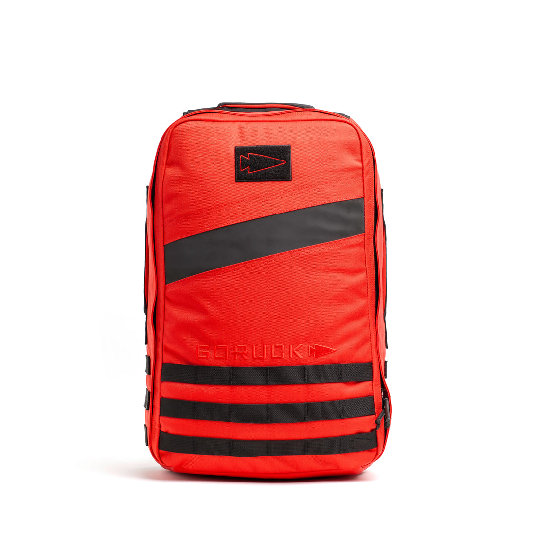 The GORUCK Rucker 4.0 is a bright red backpack with black diagonal stripes and accents, featuring the GORUCK logo—ideal for fitness training or use as a weighted rucksack during your toughest workouts.