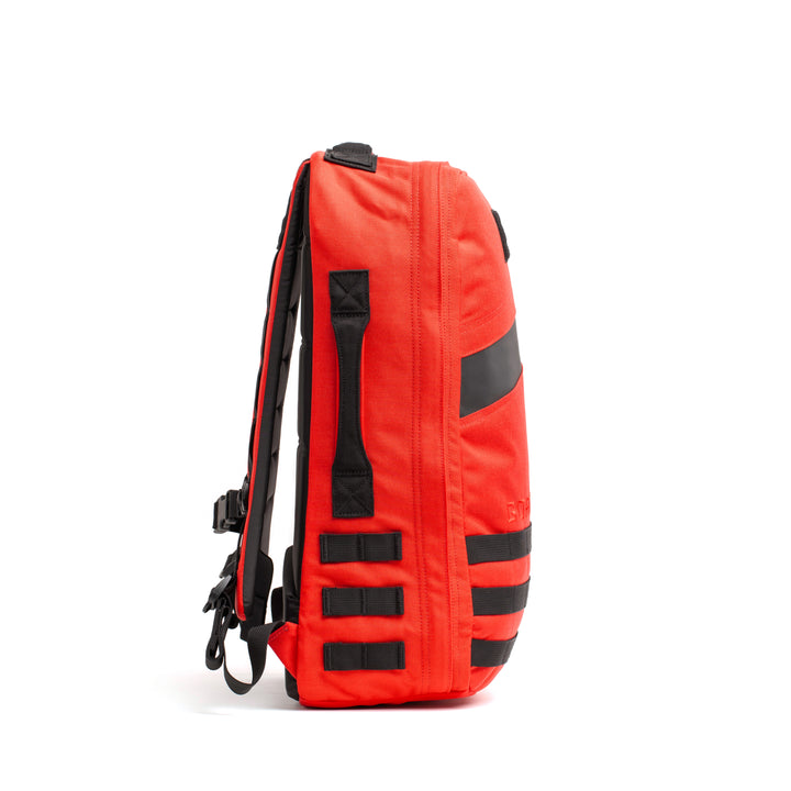 The GORUCK Rucker 4.0, a bright red backpack with black straps and accents, is displayed from the side against a white background.