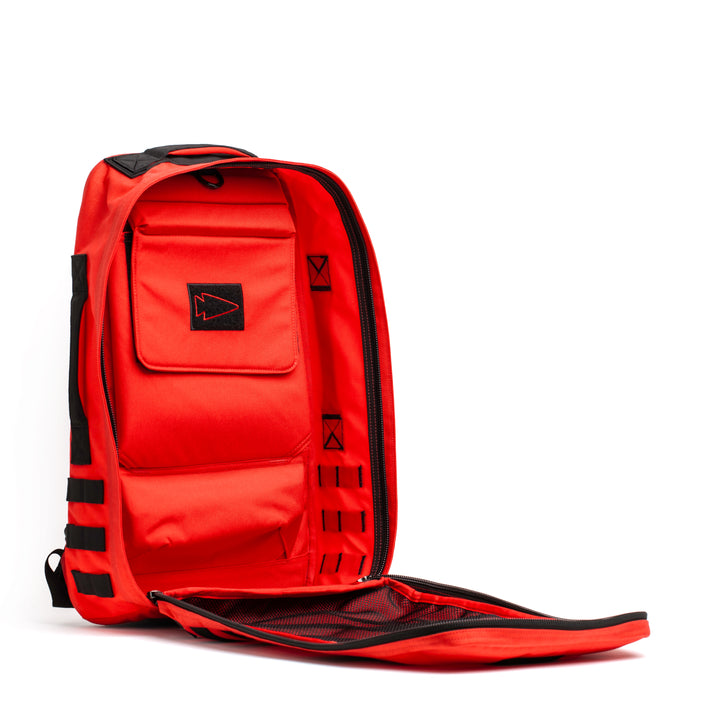 The GORUCK Rucker 4.0 is a bright red fitness training bag with black accents, featuring spacious interior compartments and a mesh pocket when unzipped.