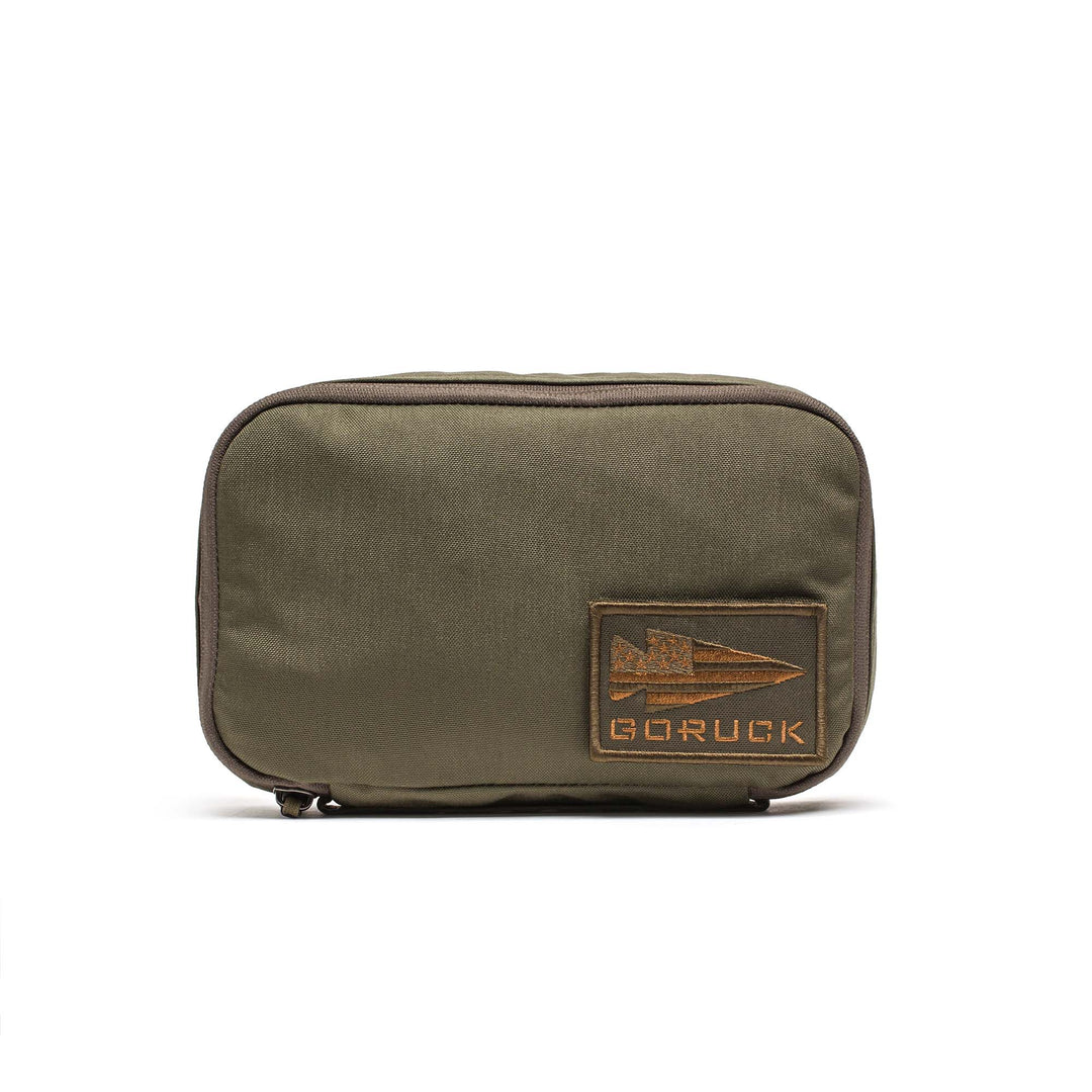 The GORUCK Shadow Pockets olive green zippered pouch is made from durable 500D Cordura and features a rectangular patch with the GORUCK arrowhead logo—ideal for organizing your gear.