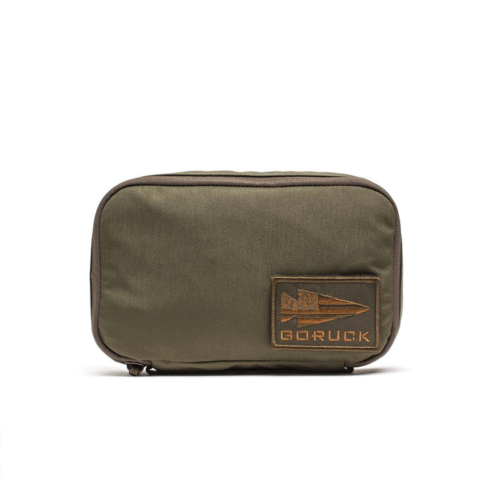 The GORUCK Shadow Pockets olive green zippered pouch is made from durable 500D Cordura and features a rectangular patch with the GORUCK arrowhead logo—ideal for organizing your gear.