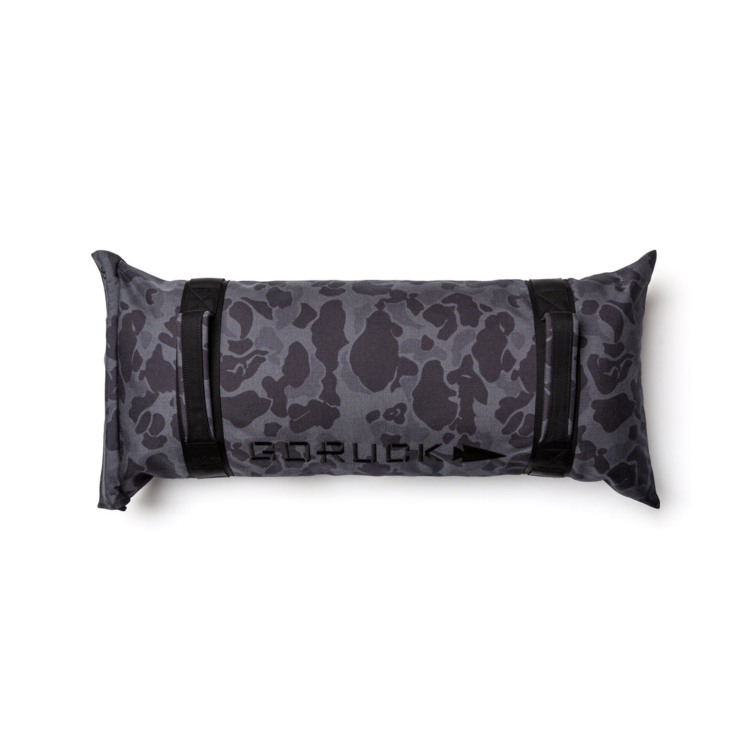 The GORUCK Simple Training Sandbag features a black and gray camo design, sturdy handles, and the "GORUCK" logo on top—built tough for any home gym and backed by the Scars Lifetime Guarantee.