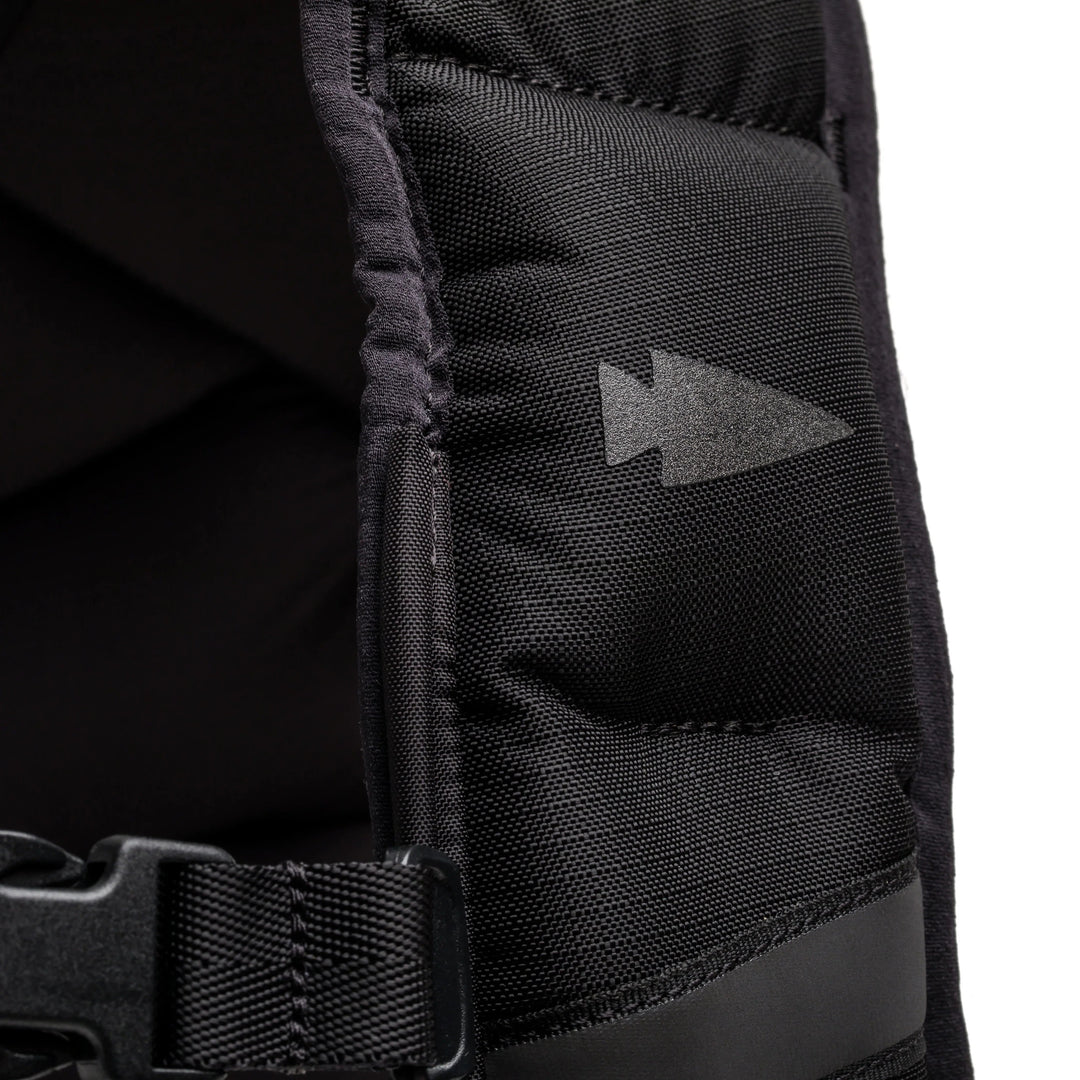 Close-up of black GORUCK rucksack strap with arrowhead logo and durable nylon stitching