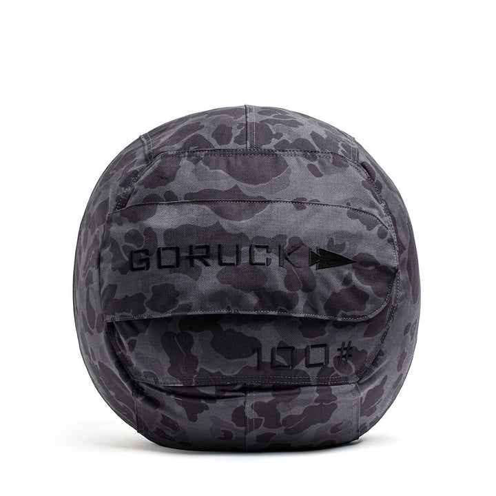 The GORUCK Sand Medicine Ball in gray camo, featuring "100" on the front and shown on a white background, is perfect for building core stability in your home gym.