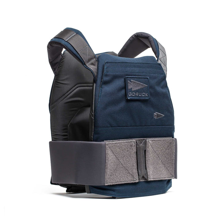 The Rucking Weight Vest is a dark blue training vest with adjustable gray straps, a front Velcro closure, and is designed to securely hold curved ruck plates, shown upright.