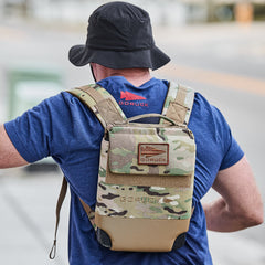 Man wearing GORUCK navy tee and camouflage backpack outdoors, rucking gear focus