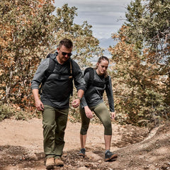 Man and woman rucking on a rugged trail in GORUCK gear with backpacks outdoors