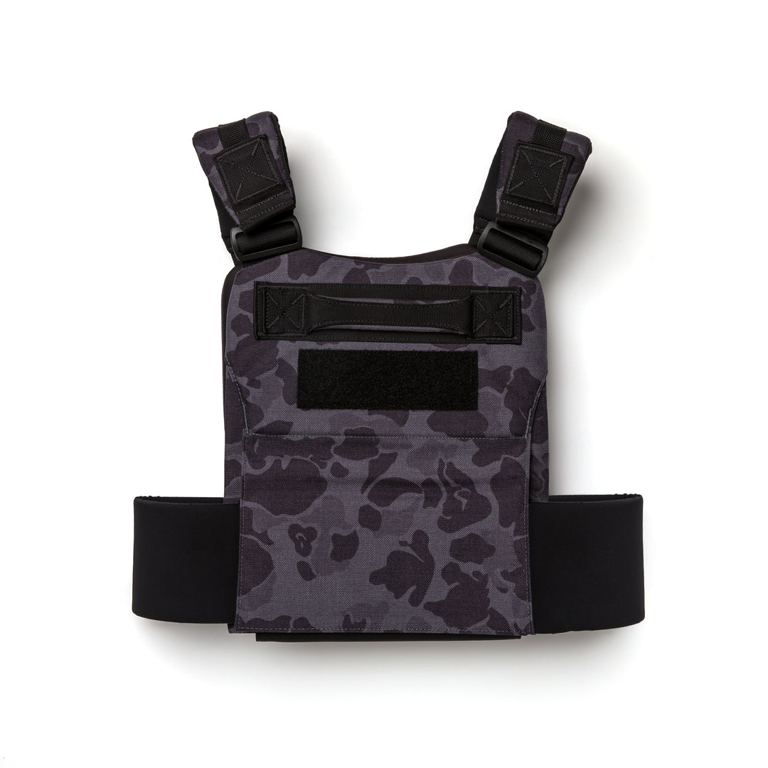 The GORUCK Training Weight Vest 2.0, shown in black and gray camouflage with adjustable shoulder straps for ruck plates, is displayed on a white background.