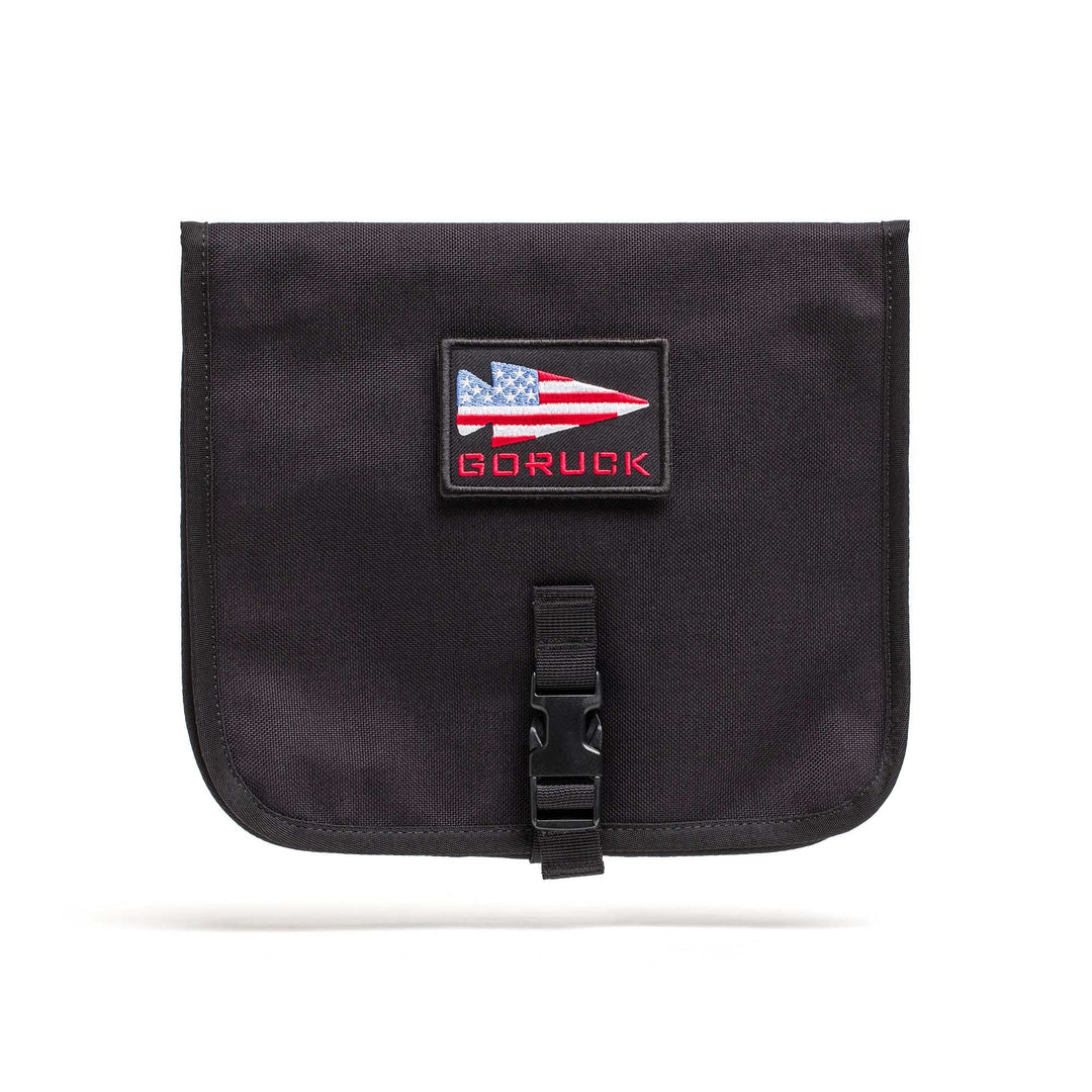 The Wire Dopp is a black pouch with an American flag patch and "GORUCK" text, front buckle closure—ideal as a travel organizer or cable pouch for your EDC essentials.