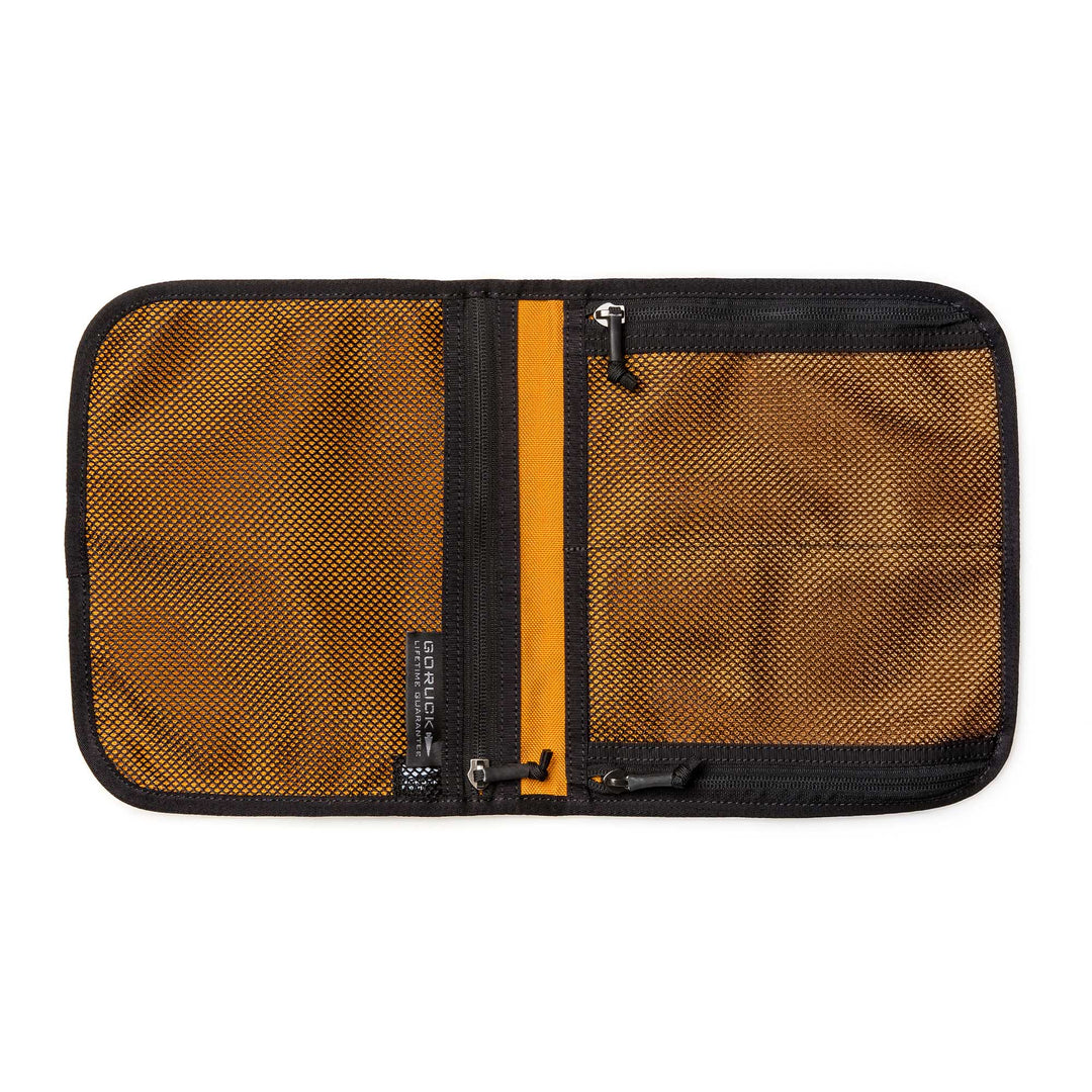 The Wire Dopp is an open brown zippered mesh travel organizer with two compartments and black trim, shown lying flat on a white background—ideal for keeping your EDC essentials organized.