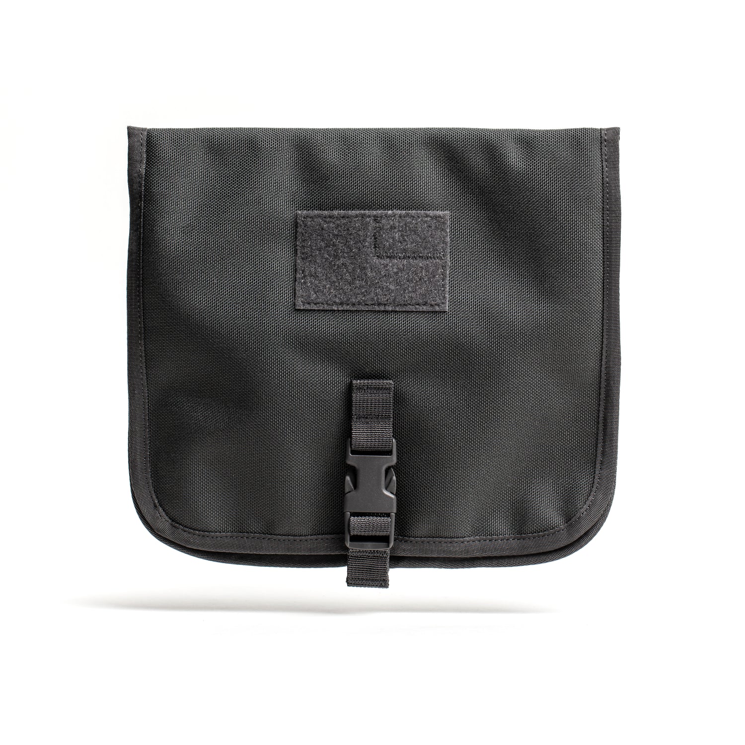 The Wire Dopp is a black CORDURA fabric pouch with a buckle closure and front Velcro patch, ideal for organizing your travel essentials. Shown on a white background.