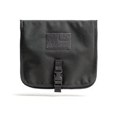 The Wire Dopp is a black CORDURA fabric pouch with a buckle closure and front Velcro patch, ideal for organizing your travel essentials. Shown on a white background.