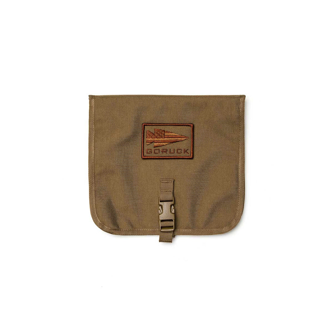 The GORUCK Wire Dopp is a brown pouch with a flap, buckle closure, and front spear logo patch—ideal for organizing your travel essentials or EDC gear.