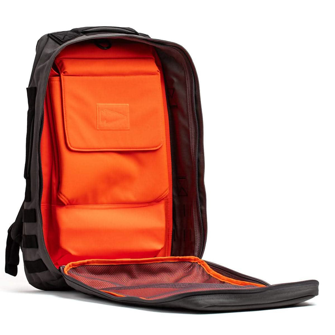 Discover the GORUCK Rucker 4.0, a black backpack with a vibrant orange interior, ideal for rucking enthusiasts. Its front flap includes a mesh pocket, perfect for storing Ruck Plates or other essentials.