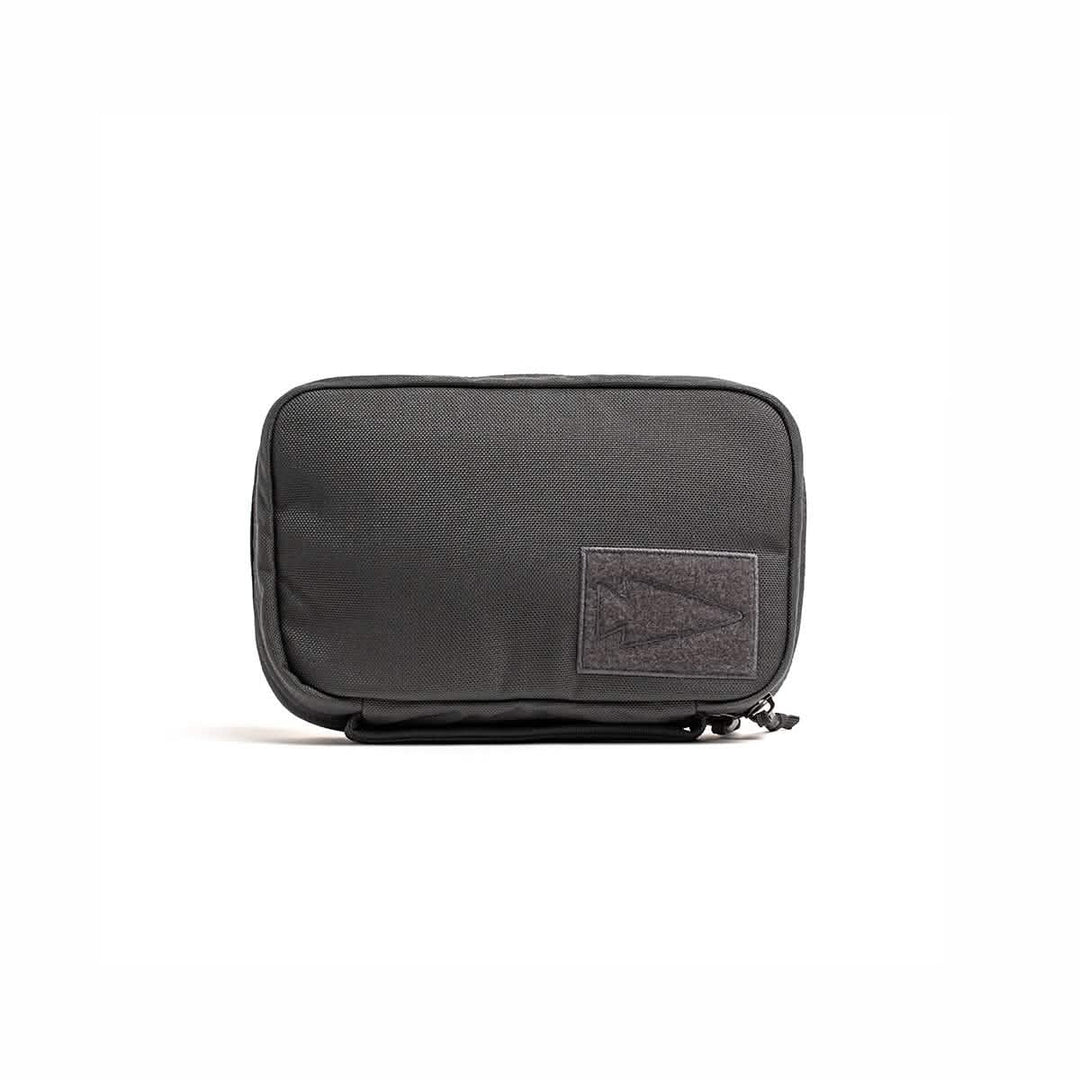 The GORUCK GR1 Field Pocket is a black zippered dopp kit with a rectangular front patch, ideal for organizing toiletries or camera gear, shown against a white background.