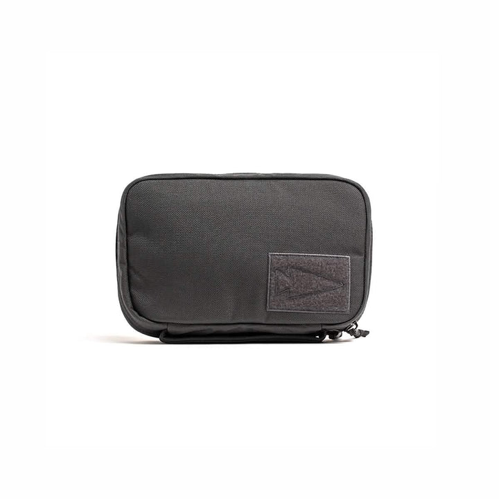 The GORUCK GR1 Field Pocket is a black zippered dopp kit with a rectangular front patch, ideal for organizing toiletries or camera gear, shown against a white background.