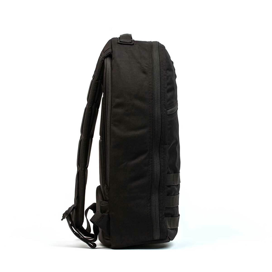 The GORUCK Bullet Ruck Laptop - 16L is shown from the side against a white background, highlighting its streamlined design, visible zipper, laptop compartment, and subtle lumbar support for comfort.