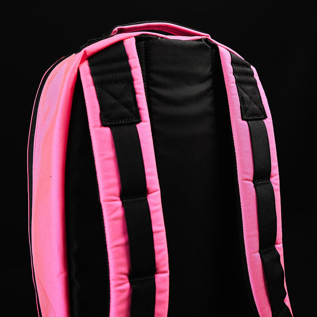 Close-up of the padded straps on a pink and black Bullet Ruck - Classic daypack by GORUCK, set against a black background, ideal for rucking.